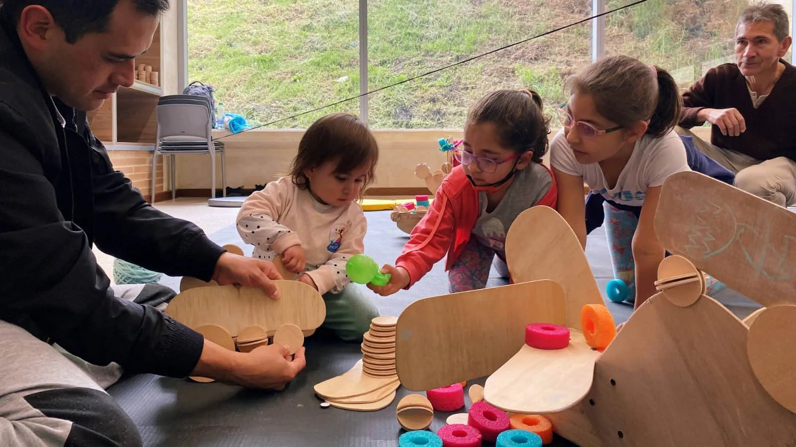 Niñas y niños jugando con figuras de madera