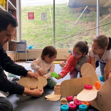 Niñas y niños jugando con figuras de madera